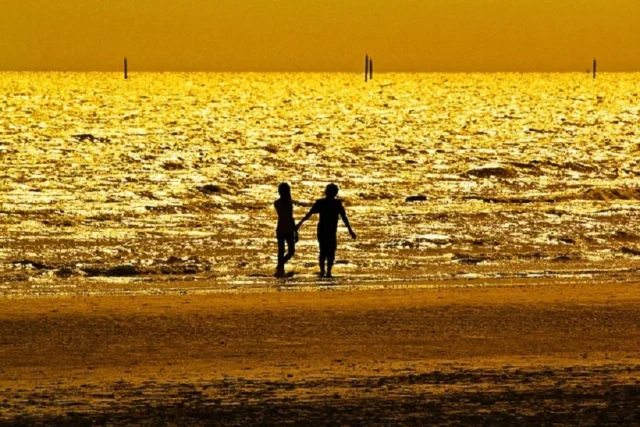 playa atardecer mar pareja