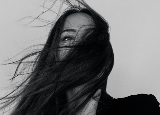 mujer cabello y vestido negro viento