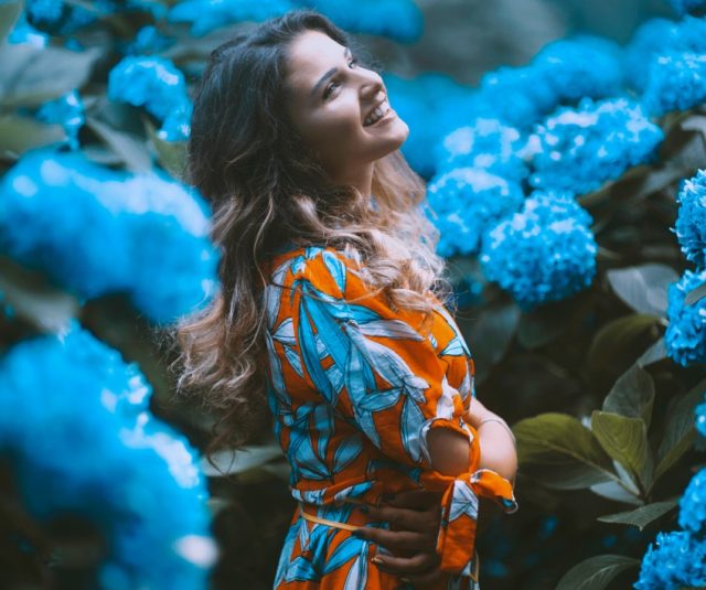 mujer en jardín con flores azules