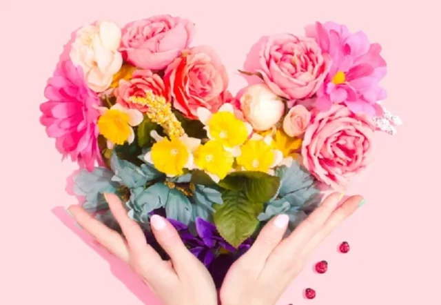 corazón de manos con flores
