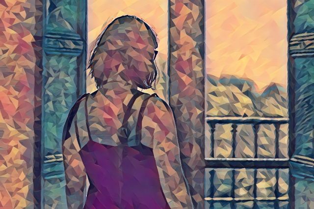mujer mirando el atardecer por la ventana