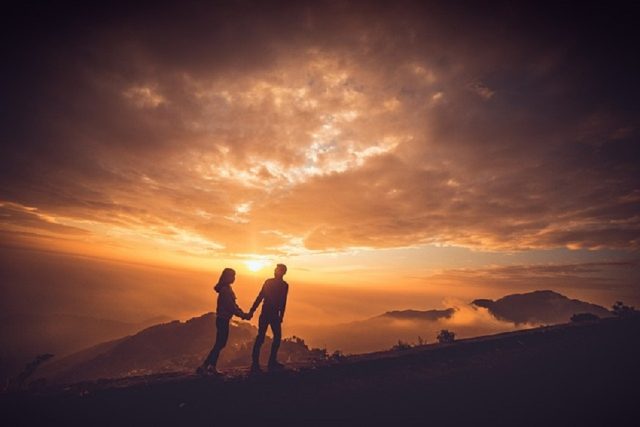 atardecer pareja subiendo colina