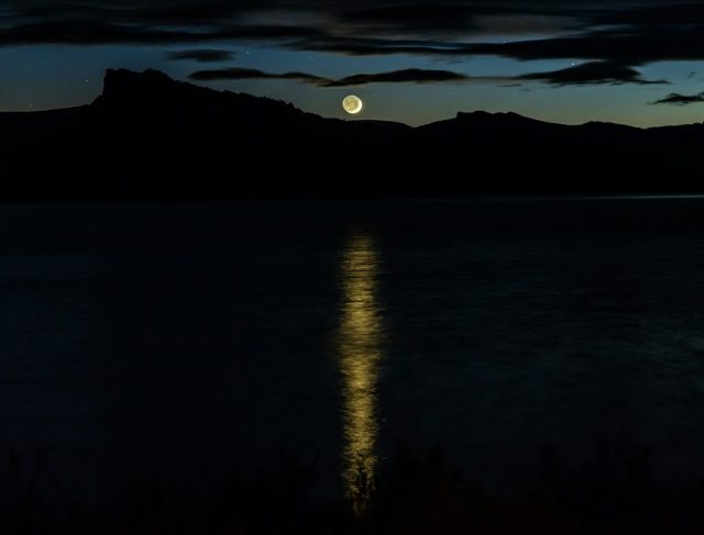 luna reflejada en el mar en medio de la oscuridad