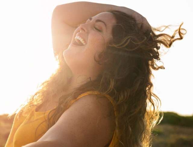 Mujer feliz Vista lateral de la mujer feliz en una tarde soleada.