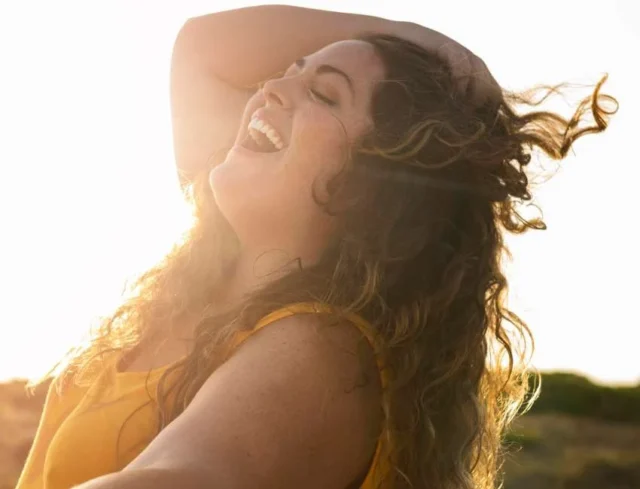 Mujer feliz Vista lateral de la mujer feliz en una tarde soleada.